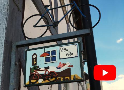Schild mit Villa Velo und youtube Symbol reineditiert.