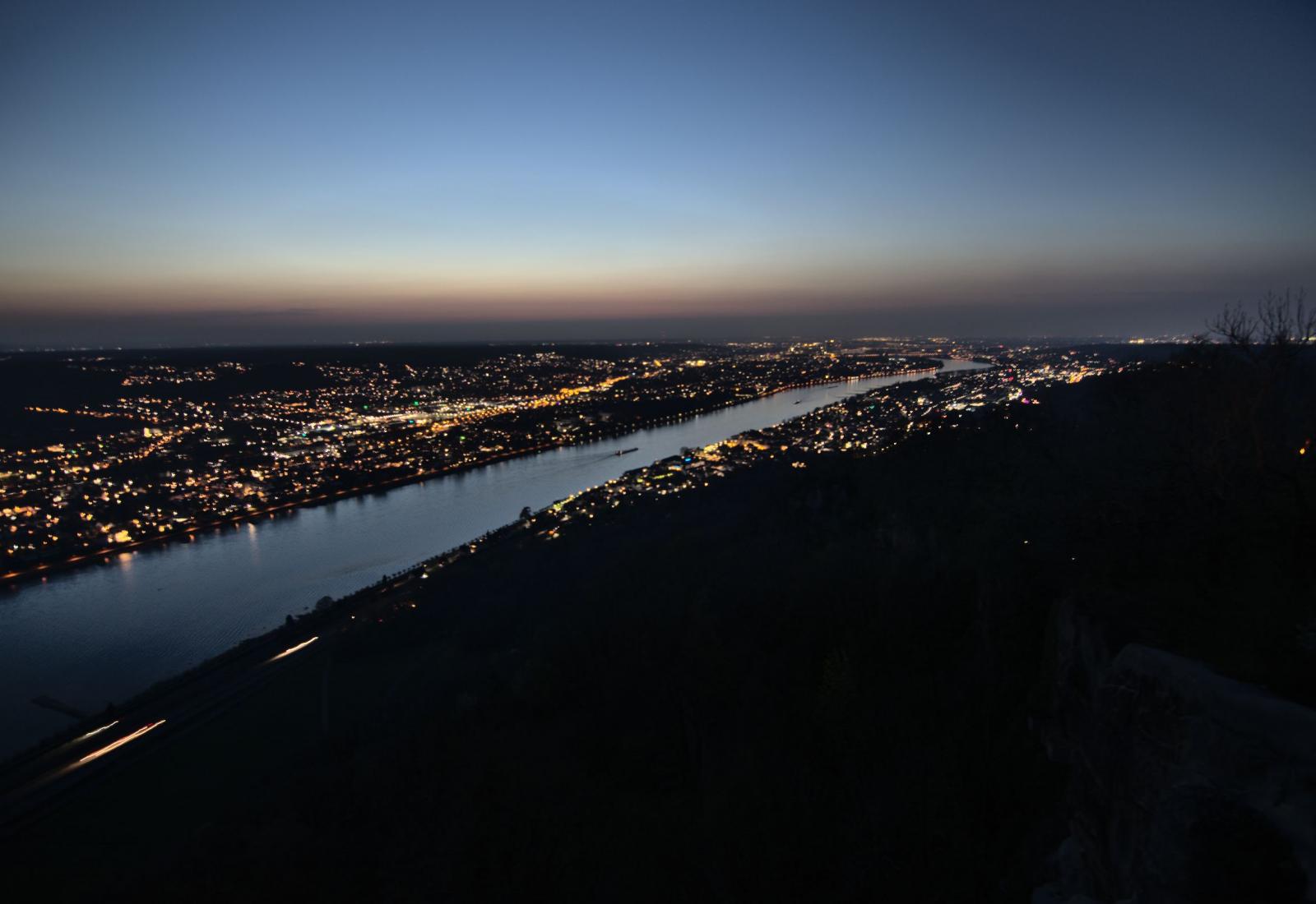 Blick von schräg oben über Bonn und das Rheintal mit Lichtern vom Drachenfels aus in der Dämmerung