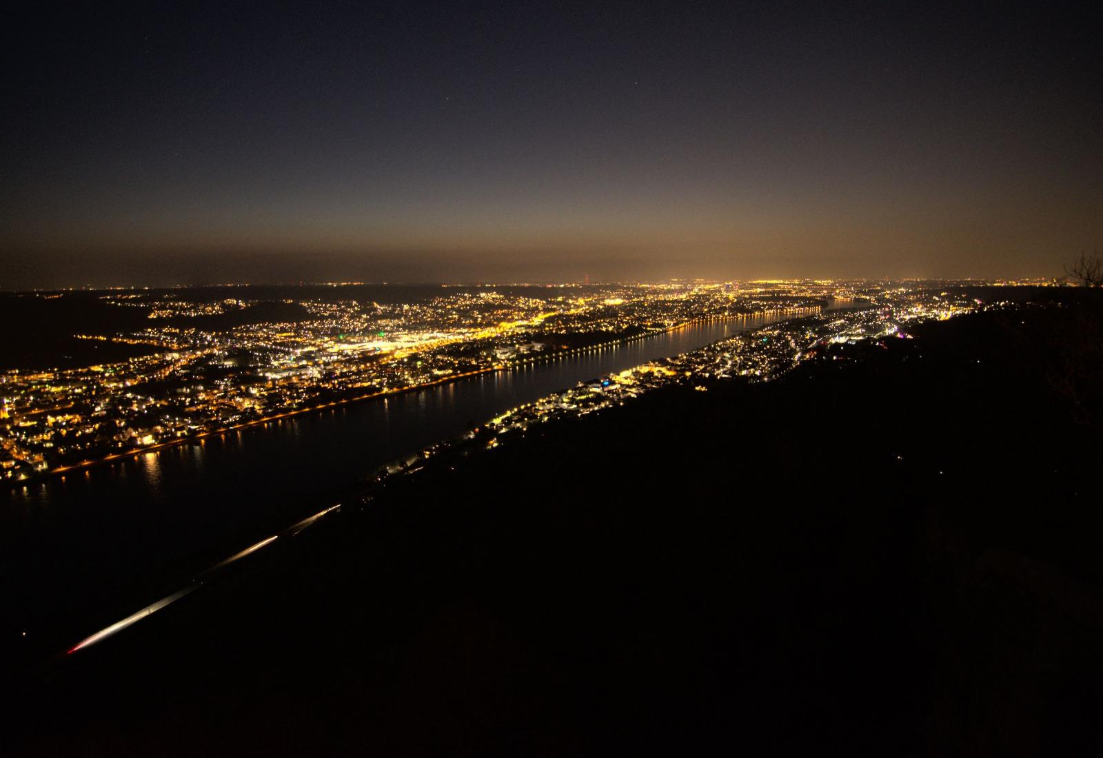 Blick von schräg oben über Bonn und das Rheintal mit vielen Lichtern vom Drachenfels aus
